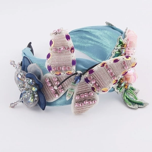 Vue détaillée d'un serre-tête papillon à paillettes avec perles et fleurs en cristal