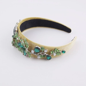 Detailed view of baroque headband with green crystals and champagne velvet base