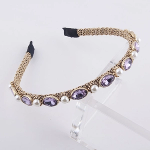 Macro shot of gold braided metal headband with lavender crystals and white pearls