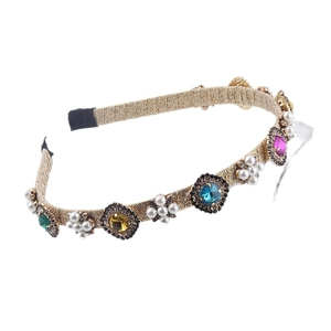 Baroque gold braided headband with colorful rhinestones and white pearls on white background