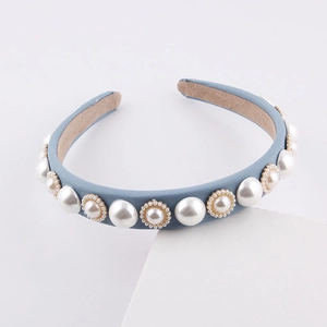 Detail view of the blue fabric headband featuring large pearls with gold bead accents