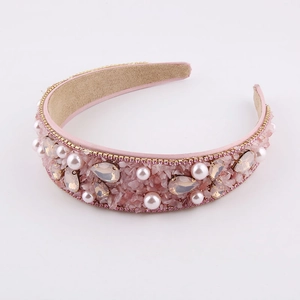 Baroque padded headband with pink crystals and pearls on a white background