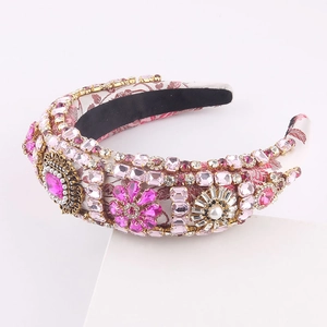 Detailed close-up of pink heart gemstones and pearls on baroque style wide headband