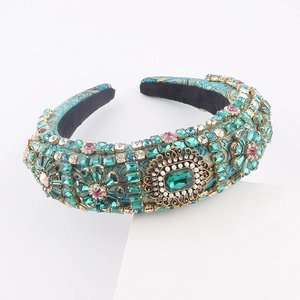 Detail of baroque headband with emerald crystals and faux pearls on blue satin