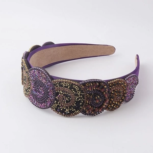 Macro shot of purple beaded headband with handcrafted circular sequin patterns