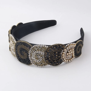 Detail of baroque headband featuring black gold and silver rhinestones in circular patterns