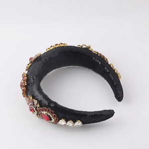 Baroque style padded headband with black sequins, gold filigree, and red crystals