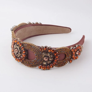 Close-up of luxury padded headband with amber rhinestones and deep brown satin texture