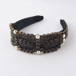 Dettaglio del cerchietto barocco con strass neri e perle bianche su velluto nero