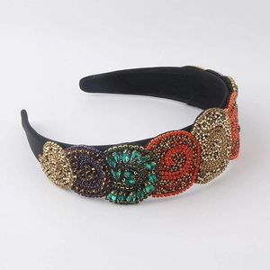 Close-up of elaborate handmade beadwork and colorful rhinestones on a wide black headband
