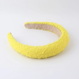 Detail of yellow thick padded headband with textured tweed fabric and non-slip lining