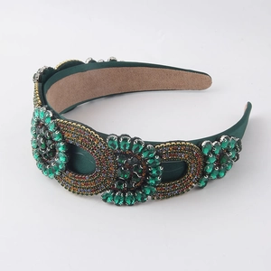 Detailed macro view of green fabric headband featuring baroque rhinestones and geometric jewels