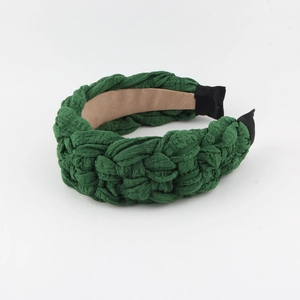 Fashionable dark green woven fabric headband with thick braided texture on white background