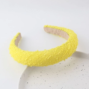 Detail of yellow padded headband with textured knit fabric and non-slip velvet lining