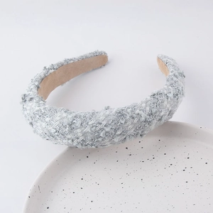 Detailed macro view of silver-grey tweed fabric with metallic glitter threads on headband