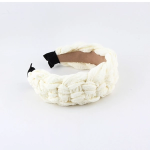 Detailed view of cream woven headband showing thick fabric texture and black end tips