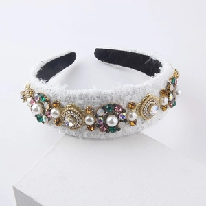 Detail of baroque white tweed headband featuring colorful rhinestones and pearls