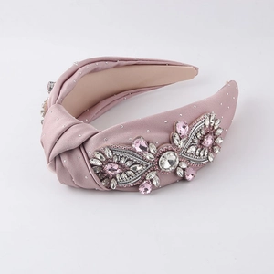 Detail of pink baroque knotted headband featuring sparkling rhinestones and satin fabric