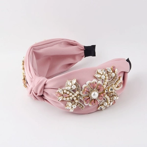 Detail eines rosa Stoff-Haarreifens mit handgefertigtem Perlen- und Strass-Blumendesign