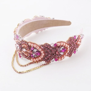 Close-up of pink rhinestone luxury headband with crystal fringes and pearl details