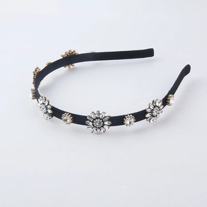 Elegant black headband with golden sunflower rhinestone accents on a white background