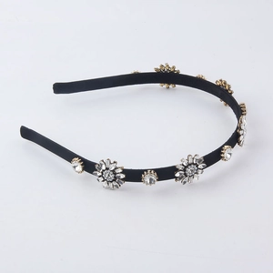Detailed close-up of sparkling crystal flower ornaments on a velvet black headband