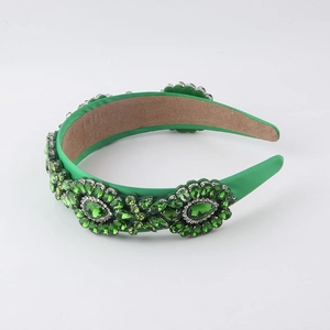 Detailed view of green velvet headband featuring sparkling rhinestone floral patterns