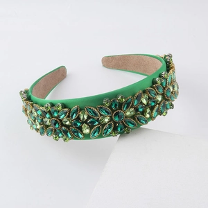 Close-up of emerald green baroque headband with intricate rhinestone floral crystal patterns
