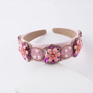 Baroque floral headband with pink crystals, pearls, and beads on a white display stand