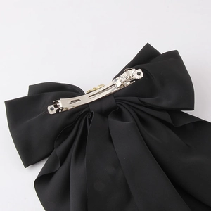Elegant black satin bow hair clip with polished silver metal spring fastener