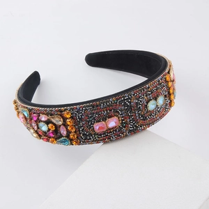 Close-up of velvet padded headband featuring colorful rhinestones and vintage gemstones
