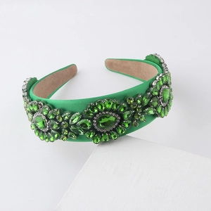 Close-up of green velvet headband with intricate emerald rhinestones in flower patterns