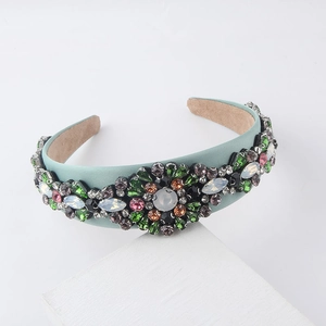 Detailed view of Baroque headband with colorful crystal flowers on light teal satin fabric