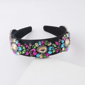 Detail of colorful rhinestones and jewels arranged in floral patterns on a velvet headband