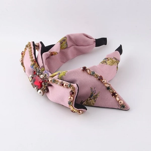 Dettaglio del cerchietto barocco rosa floreale con grande strass rosso e perle fini