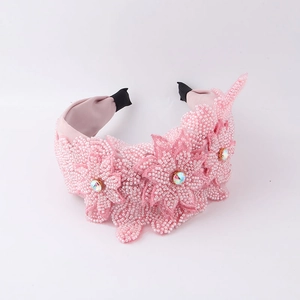 Vue détaillée du serre-tête floral rose avec perles, gemme irisée et doublure textile