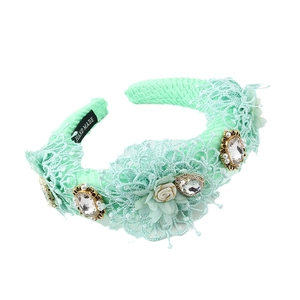 Mint green Baroque headband with lace flowers, crystals, and pearls on white background