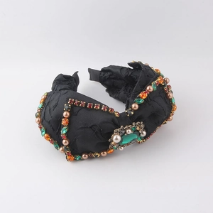 Dettaglio del cerchietto nero con strass colorati e perline finte applicate