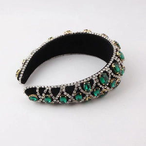 Close-up of velvet padded headband with crystal lattice and large emerald green gems