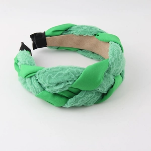 Détail d'un serre-tête tressé vert avec mélange de tissu lisse et dentelle plissée