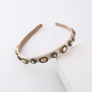 Macro detail of vintage beige leather headband with champagne crystals and gold metal studs