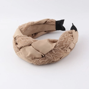 Détail du serre-tête tressé beige avec textures de tissus mixtes et extrémités en tissu côtelé noir