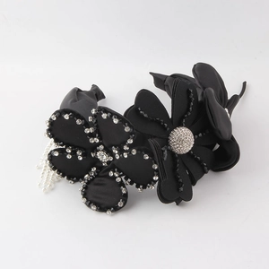 Détail du serre-tête fleurs en tissu noir avec strass et glands de perles blanches