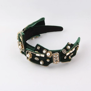 Detail of dark green velvet headband with large pearls, rhinestones and golden floral accents
