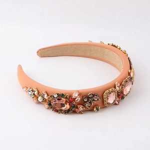 Detailed macro view of orange-pink padded headband with crystals, pearls and gold butterflies