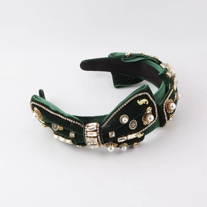 Elegant dark green velvet headband with rhinestones and pearls in a 45-degree angle view