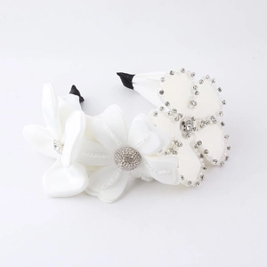Vue macro de bandeaux floraux en satin blanc avec cristaux, perles et broderies fines