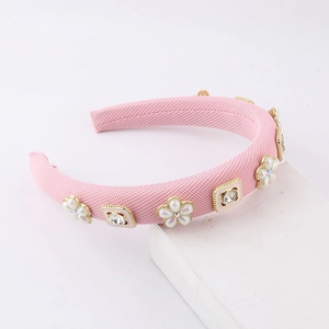 Pink sponge padded headband with pearl flowers and rhinestones for women on white background