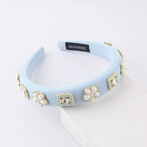 Detail of light blue sponge headband featuring pearl flowers and sparkling crystals