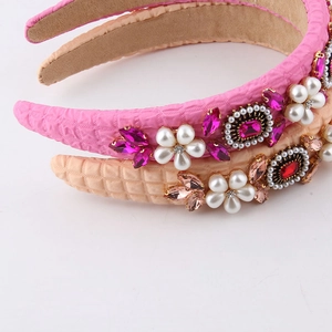 Close-up of fabric headbands with elegant pearl flower patterns and colorful crystals